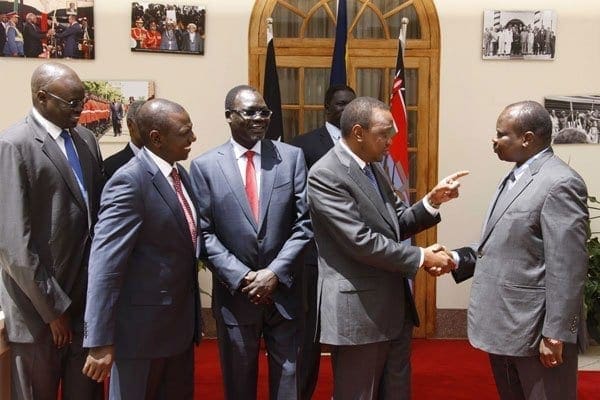 President Uhuru Kenyatta (second from right) shakes hands with South Sudan's former secretary-general of the ruling party, Pagan Amum, on May 8, 2014, in Nairobi. Amum was one of the politicians freed after their trial for treason was stopped in a move seen as a step towards ending brutal civil war. AFP PHOTO / PSCU