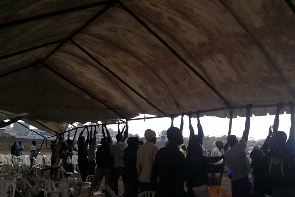 People try to prop up a tent that had been blown away by the strong winds. Strong winds, heavy rains, mud and a water-logged venue first delayed then disrupted the launch of public signature hunt by the Okoa Kenya Movement. PHOTO | AGGREY MUTAMBO
