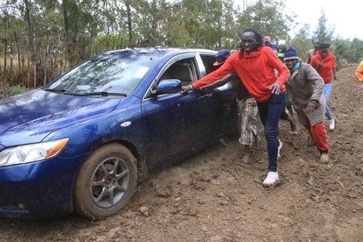 Olympics women's 800m bronze medalist Margaret Nyairera (in red jacket) is assisted by villagers of Mureru in Kieni to push a car she was riding in to the homecoming party of Olympic 400m hurdles silver medalist Boniface Mucheru. PHOTO | JOSEPH KANYI