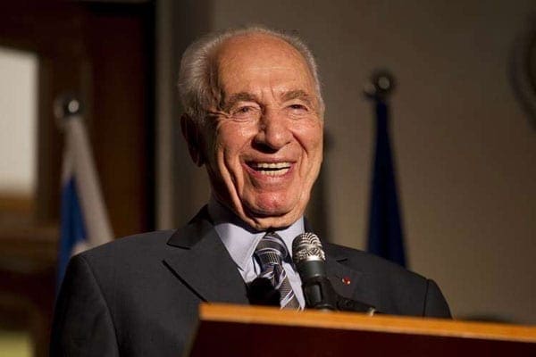 Former Israeli President Shimon Peres laughing as he addresses the annual Bastille Day reception at the French ambassador's residence in Tel Aviv on July 4, 2011.