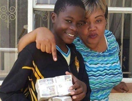 Gift Osinya, the adopted son of Mike Sonko, with the bundle of cash he received from the Nairobi Senator for passing his KCPE exams. PHOTO | COURTESY