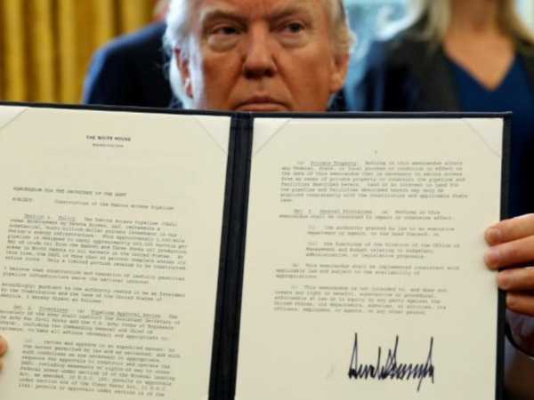 US President Donald Trump holds up a signed executive order to advance construction of the Dakota Access pipeline at the White House in Washington January 24, 2017. /REUTERS