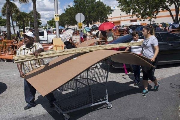 People push a cart full of wood and supplies outside a Home Depot store in Miami, Florida, as they prepare for Hurricane Irma on September 7, 2017. PHOTO | SAUL LOEB | AFP