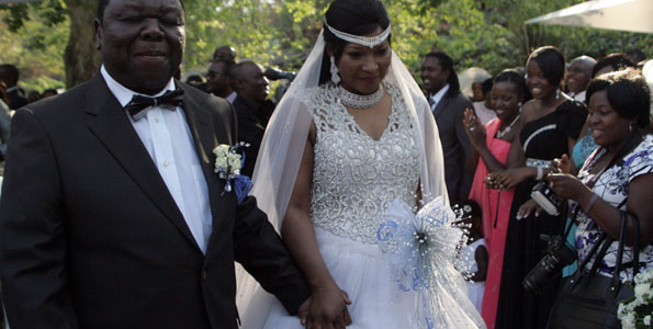 Zimbabwe Prime Minister Morgan Tsvangirai holds hands with his wife Elizabeth Macheka after exchanging vows at a customary law ceremony during their wedding held in Harare on September 15, 2012.