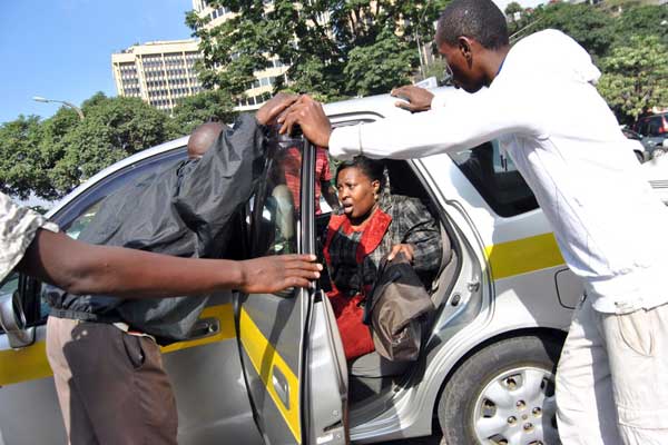 Striking matatu touts force a woman out of a taxi during the Nairobi matatu strike on March 5, 2014. PHOTO | ANTHONY OMUYA | FILE