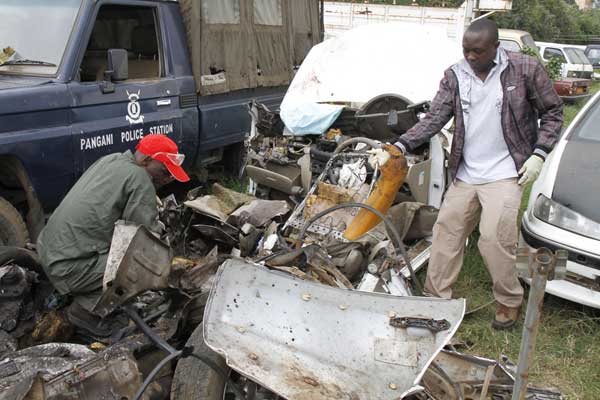 Experts from the bomb disposal unit look for evidence from the wreckage of the car that exploded at Pangani Police Station on April 23, 2014, killing two policemen and two terrorists that they had arrested. PHOTO | JEFF ANGOTE