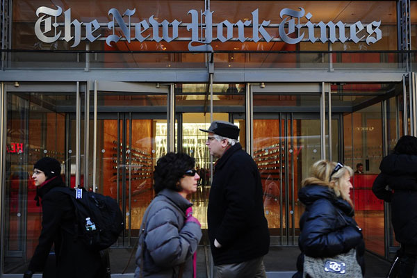 PHOTO | EMMANUEL DUNAND | FILE People walk by the entrance to The New York Times in New York on March 8, 2011.