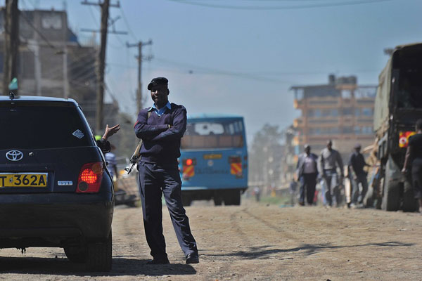 A police officer stops a motorist at a road block set up in the Somali district of Eastleigh on April 9, 2014 in the Kenyan capital, Nairobi.  Police arrested 34 people Monday night in a crackdown on illegal immigrants in Nairobi’s South C estate. AFP PHOTO / TONY KARUMBA