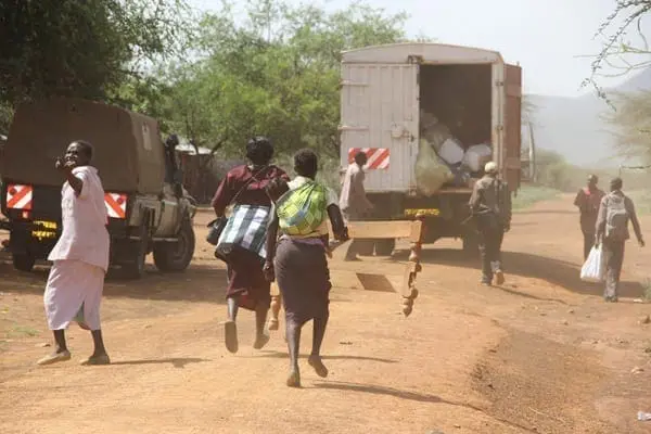 Residents of Mukutani in Baringo County run after a truck on June 19, 2014 after eight houses were burnt down by attackers suspected to be from a neighbouring community. Following the conflict, many people are now camping in schools. PHOTO/JARED NYATAYA
