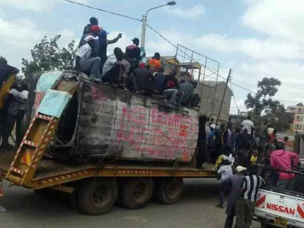 Youths carry the shell of a burnt matatu to the office of Cord leader Raila Odinga, June 8, 2016. Photo/COURTESY