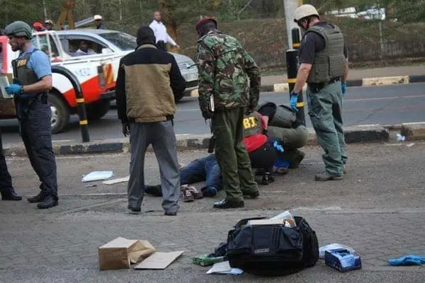 Security officers including the Kenyan officers and FBI detectives search the body of a man gunned down outside the US embassy on October 27, 2016. PHOTO | ANTHONY OMUYA | NATION MEDIA GROUP