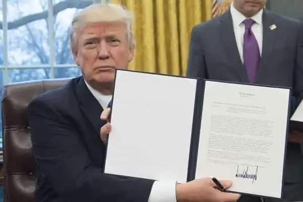 President Donald Trump Trump pulls US out of Trans-Pacific Partnership deal: President Donald Trump holds up an executive order withdrawing the US from the Trans-Pacific Partnership after signing it in the Oval Office of the White House in Washington, DC, on January 23, 2017. PHOTO | SAUL LOEB | AFP