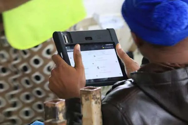 An IEBC official holds a KIEMS gadget during