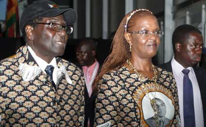 Zimbabwe's president Robert Mugabe (L) and his wife Grace Mugabe (R) leave the conference venue during the opening day of Zimbabwe's ruling Zanu-PF party annual conference in Chinhoyi on December 13, 2013. PHOTO | JEKESAI NJIKIZANA | FILE