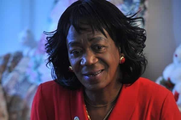 In this Tuesday, November 24, 2009 photo, President Barack Obama's aunt, Zeituni Onyango, poses in her home in Boston with a framed photograph of Preident-elect Barack Obama, President George W. Bush and their wives, taken on inauguration day, January 20, 2009 in Washington. (AP Photo/Josh Reynolds)