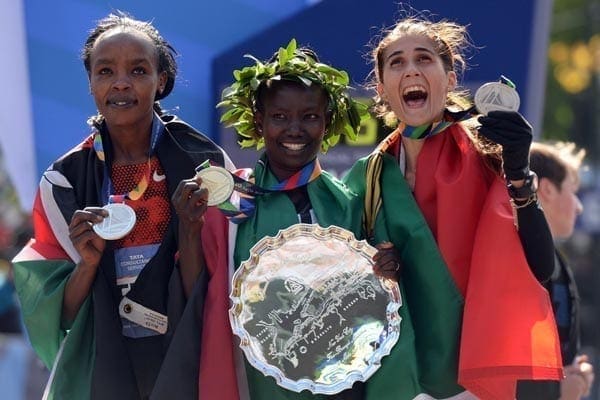 First place finisher Mary Keitany (centre) of Kenya poses with compatriot Jemima Sumgong (left, second)  and Sara Moreira (right, third) of Portugal. PHOTO | DON EMMERT