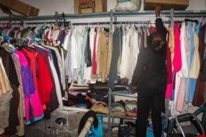 An African migrant selects clothes at the Karibu Association’s storage room in Madrid. The organization offers food, clothes and free Spanish lessons to African migrants. It also runs a shelter where homeless African children and abused women live. Image by Wairimu Michengi. Spain, 2015