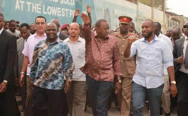 President Uhuru Kenyatta walks with Mombasa Governor Hassan Joho (right) and Nyali MP Hezron Awiti (left) on Wednesday after officially opening a new wing of the Kongowea Market.