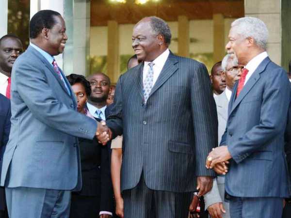 Former UN secretary general Kofi Anan watches as Opposition leader Raila Odinga and President Mwai Kibaki shake hands outside Harambee House, after brokering a peace deal  in 2008 following post-election violence. /FILE