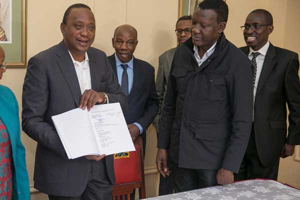 President Uhuru Kenyatta (left )after signing