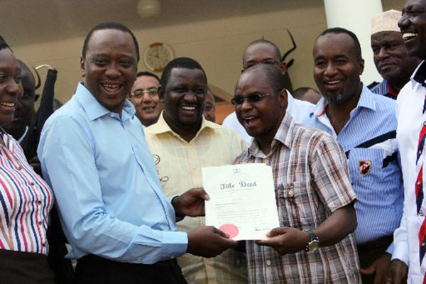 President Uhuru Kenyatta giving title deeds for squatters to Kilifi Governor Amason Kingi at State House, Mombasa on August 29, 2013. PHOTO/FILE